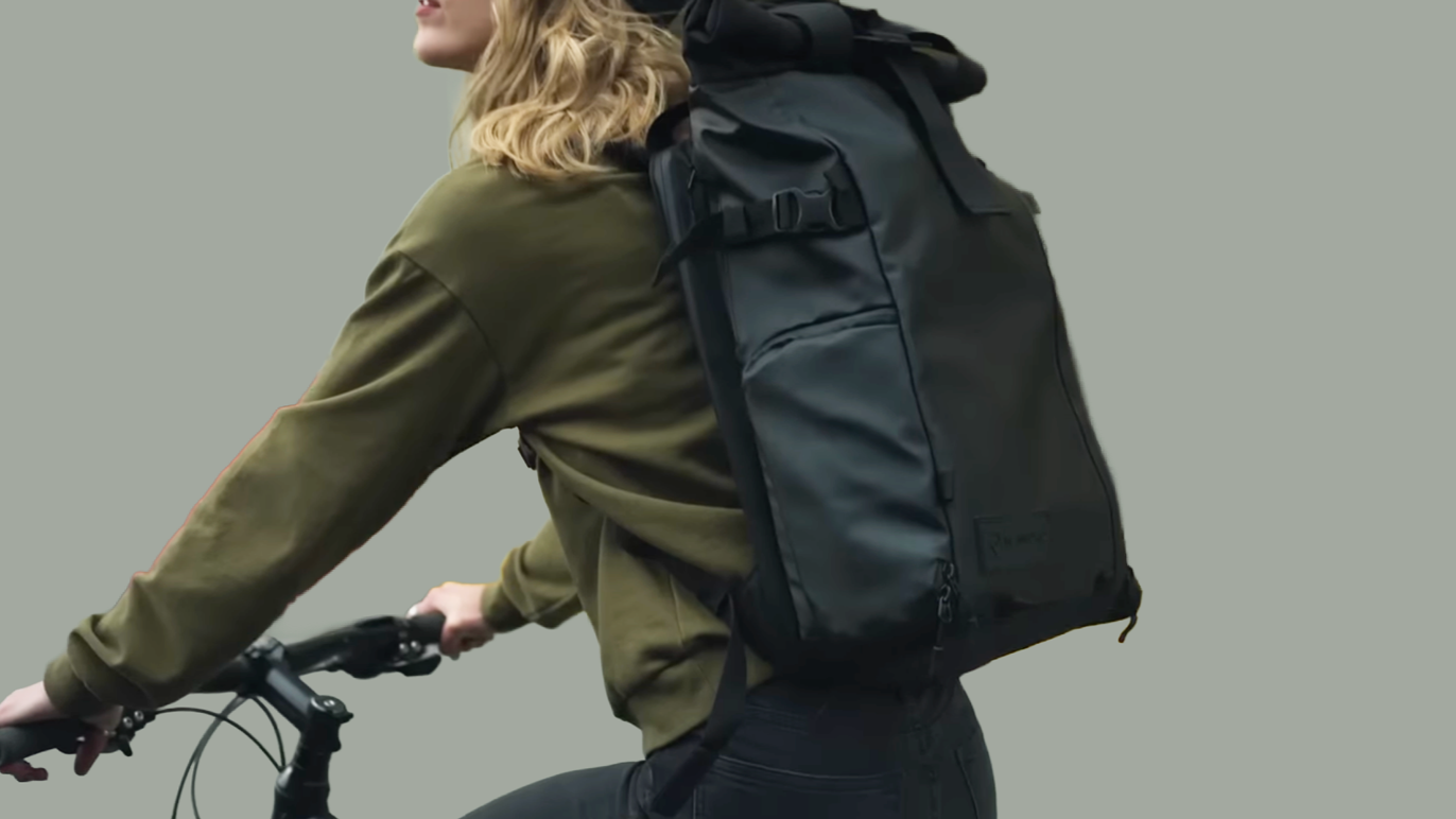 Person on a bicycle, wearing a WANDRD backpack.