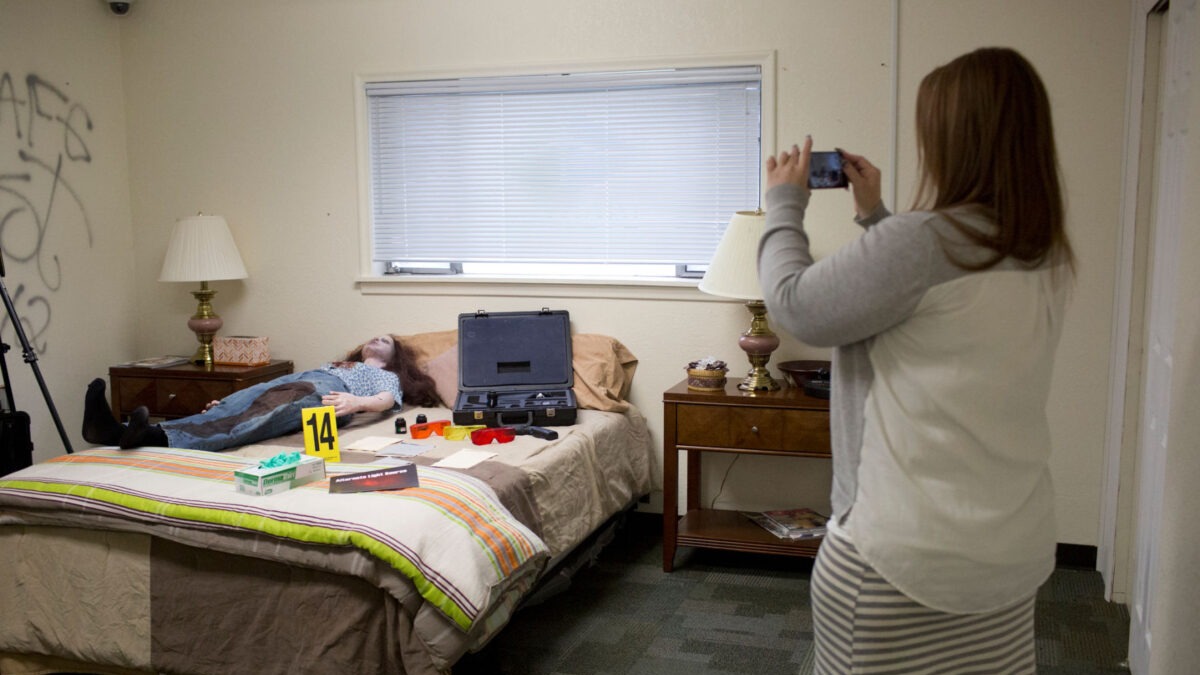 Student taking a photo of a staged forensic scene during a training exercise. Courtesy of Sammy Jo Hester, The Daily Herald.