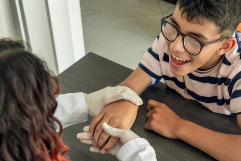 medical professional holding child's hand
