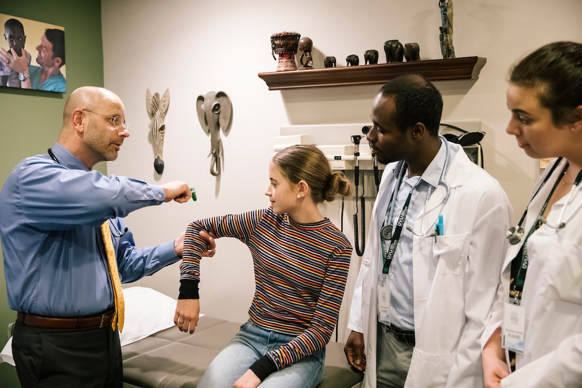 Instructor teaching students how to check reflexes