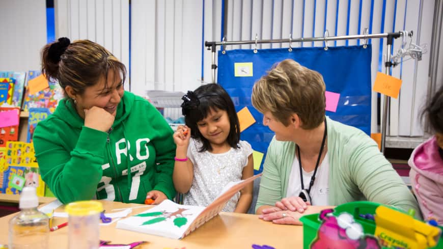 Teacher and parent working with child.