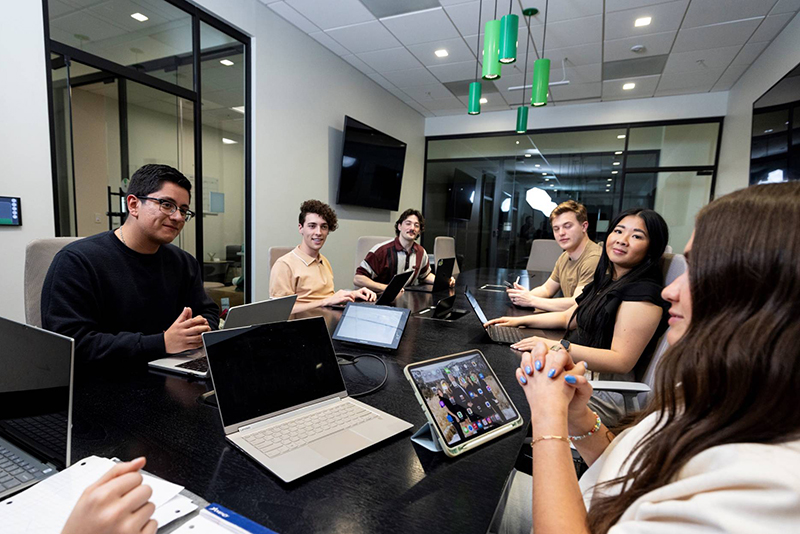 group of students working at desk in conference room