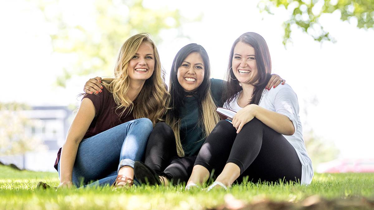 Three women sitting together on UVU campus