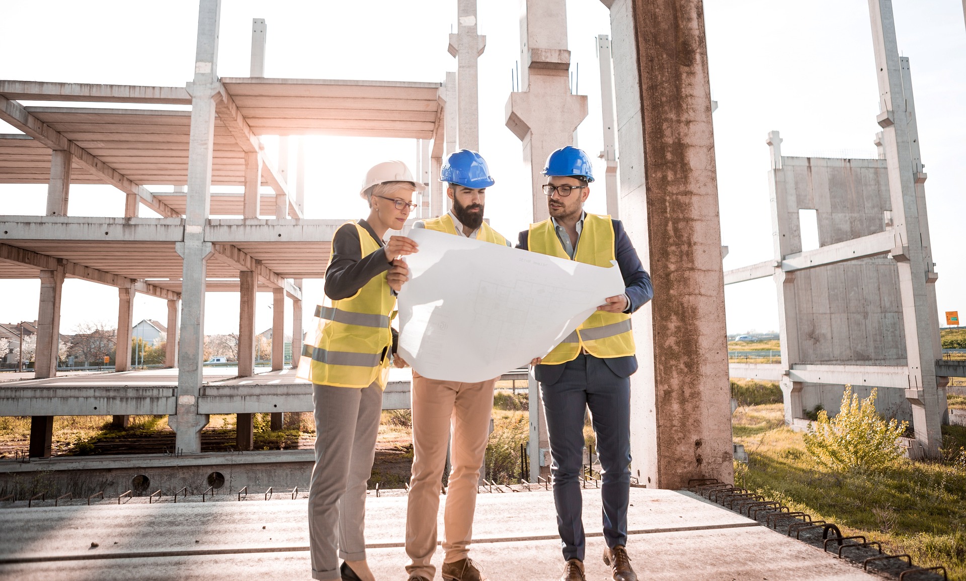 Three architects looking at blueprints