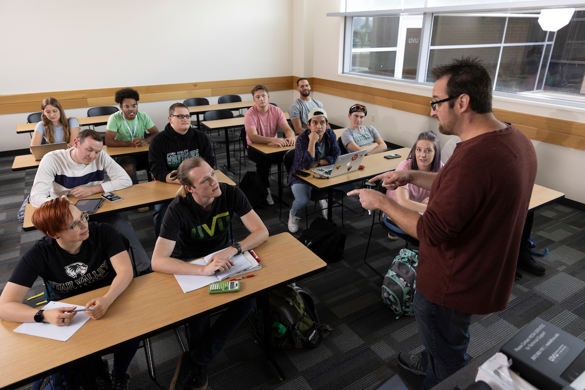 professor teaching a group of students in a classroom