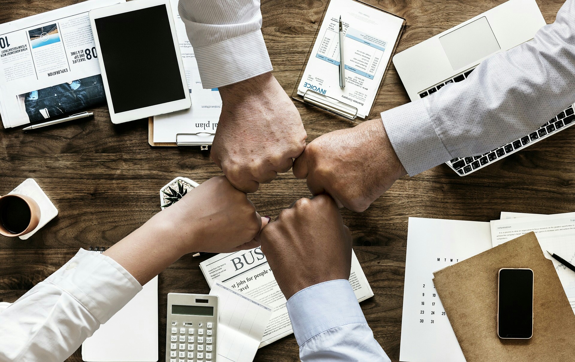 Fists arranged in a circle overlooking a desk