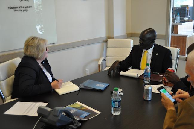 Rhona Rahlf, President of Utah Valley Chamber of Commerce, discusses cooperative ideas with Minister Ecweru. 