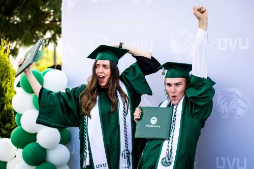 guy and girl in green cap and gowns