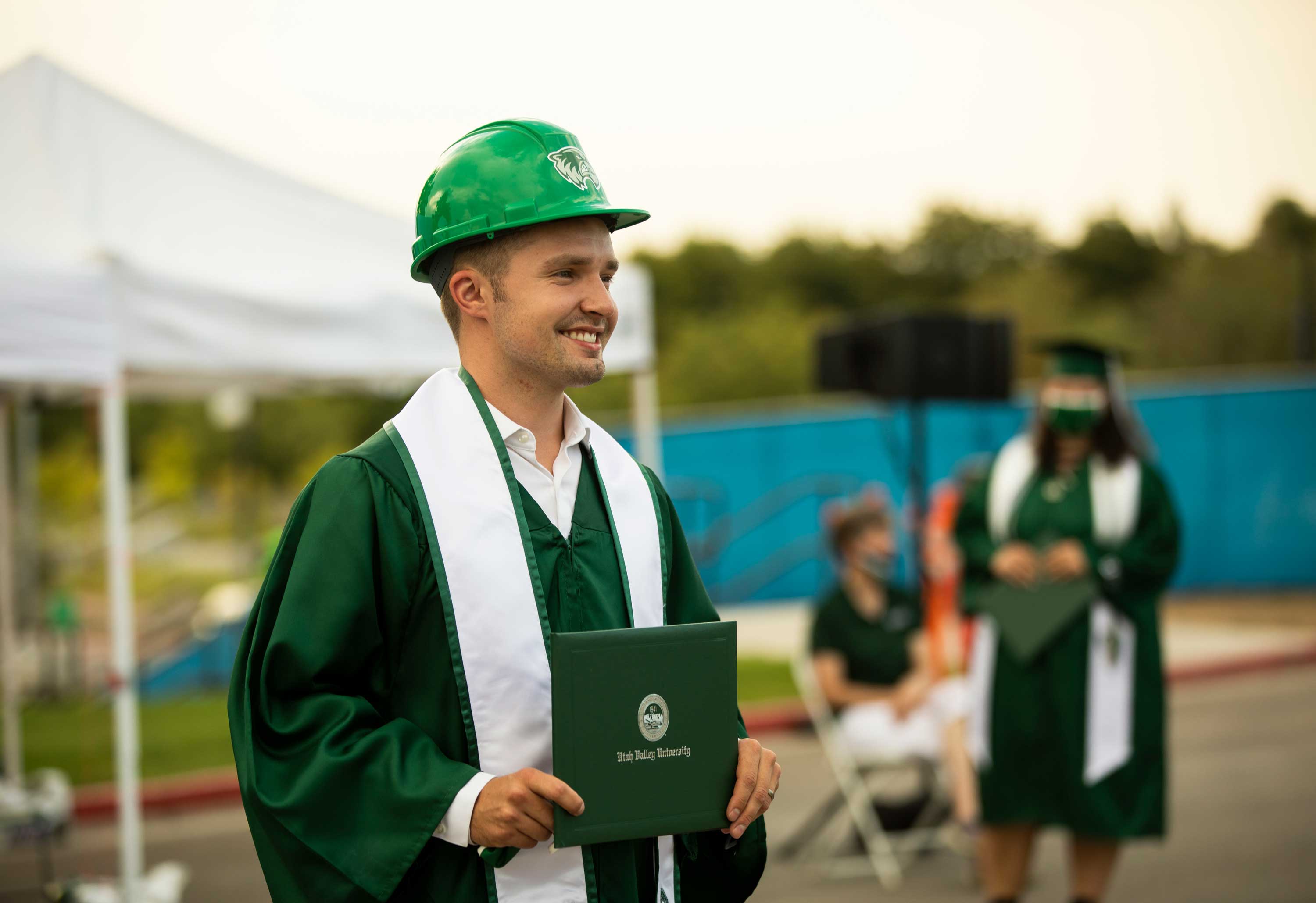 guy in a hard hat holding diploma