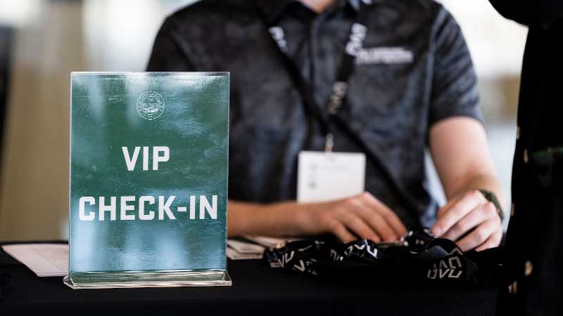 Dress Code A V.I.P. checkin sign with someone checking people in.