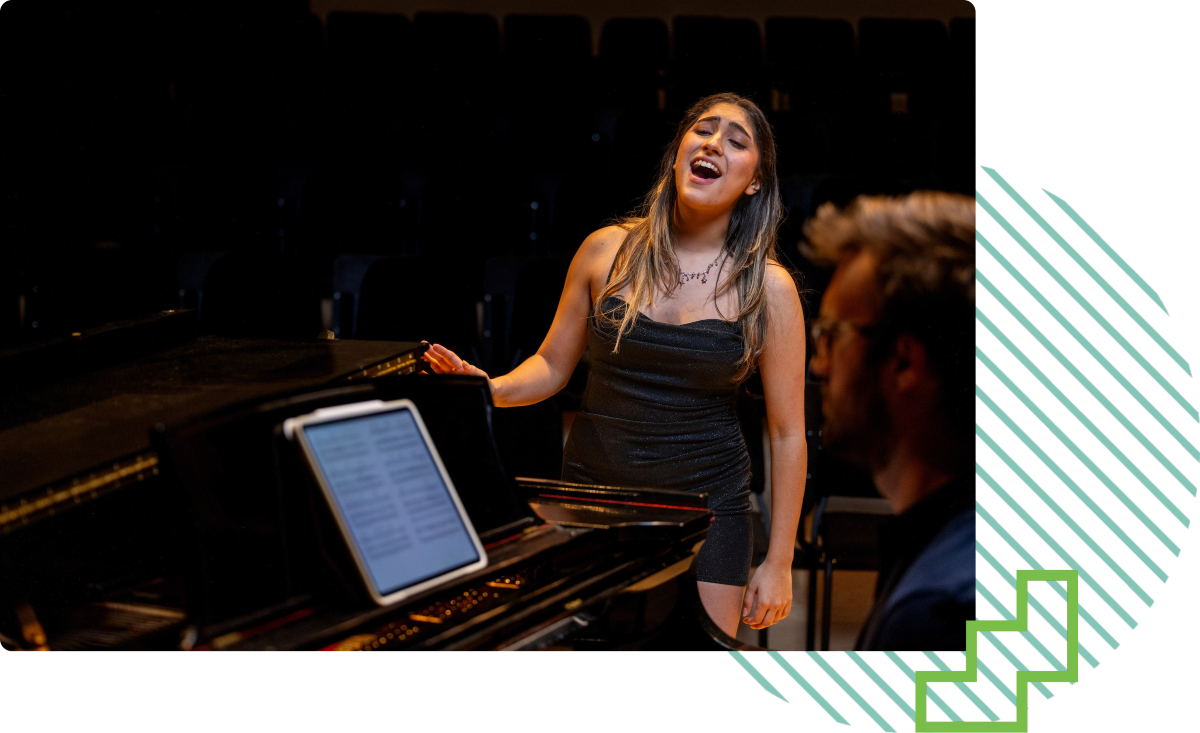 person singing in front of a piano