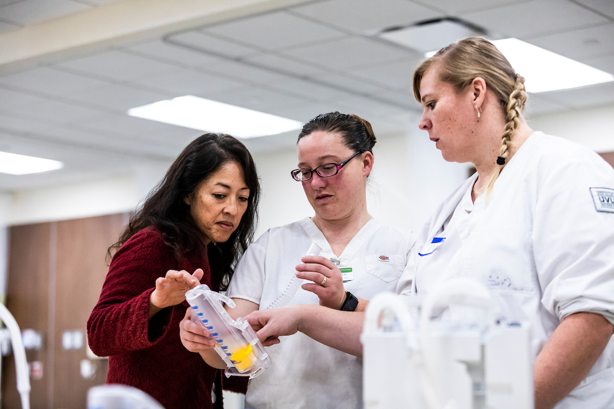 professor helping nursing students