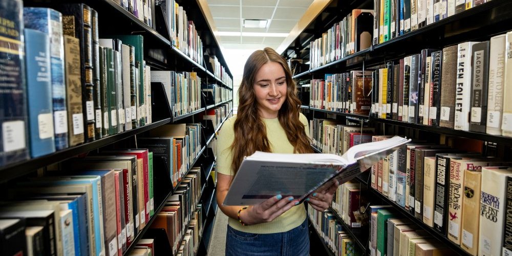 Student reading a book in the library