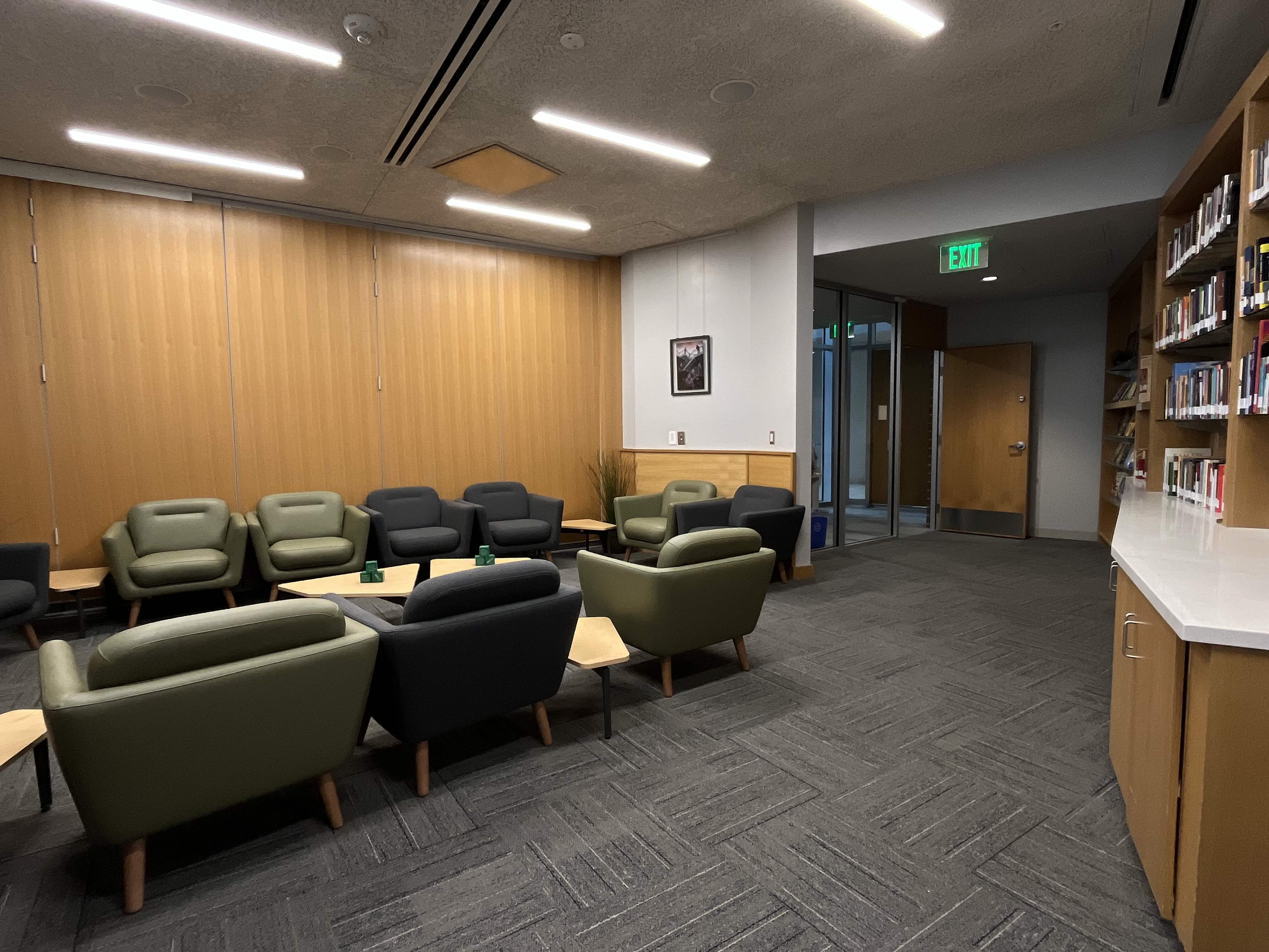 A picture of the convening room inside UVU's Reflection Center. An open room with arm chairs and bookshelves full of books.