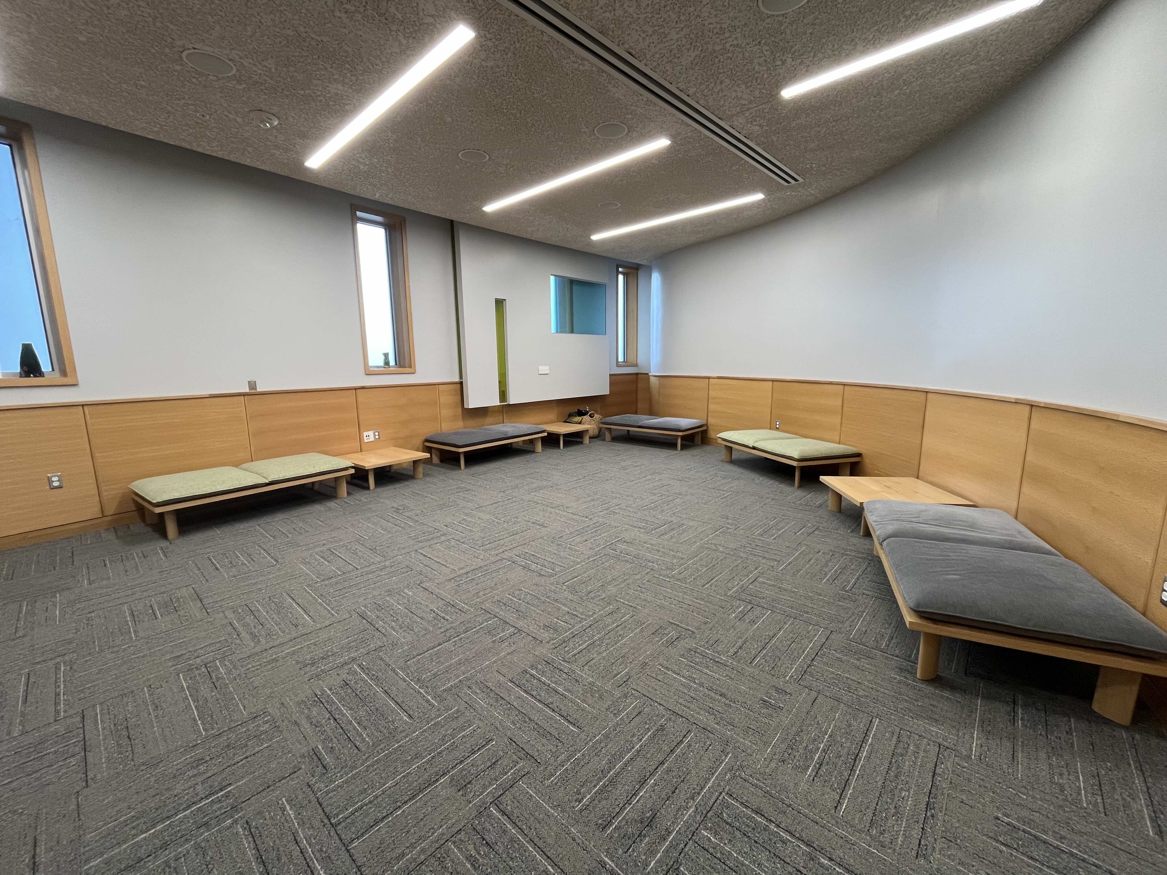 The prayer room inside the Reflection Center at UVU, an open room with arm chairs, a sofa and floor cushions