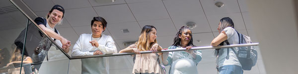 UVU students smiling down over a railing