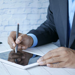 man writing on a tablet