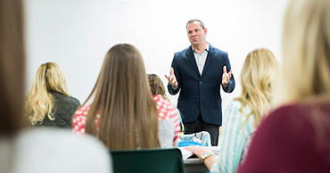 man in a suit teaching a class