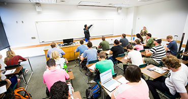 man in a suit teaching a class