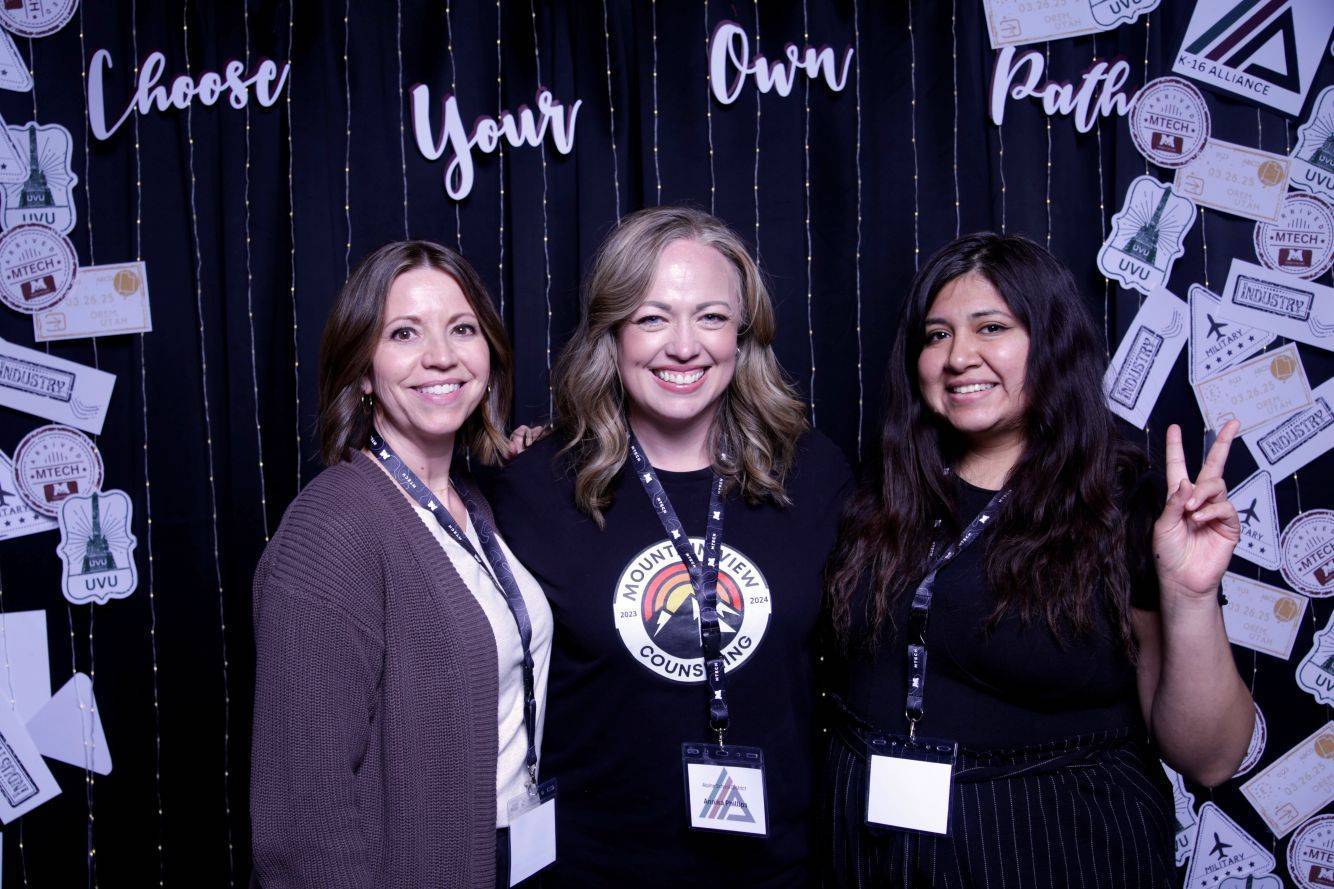 Past K-16 Conference goers posing for a photo in front of a prop area