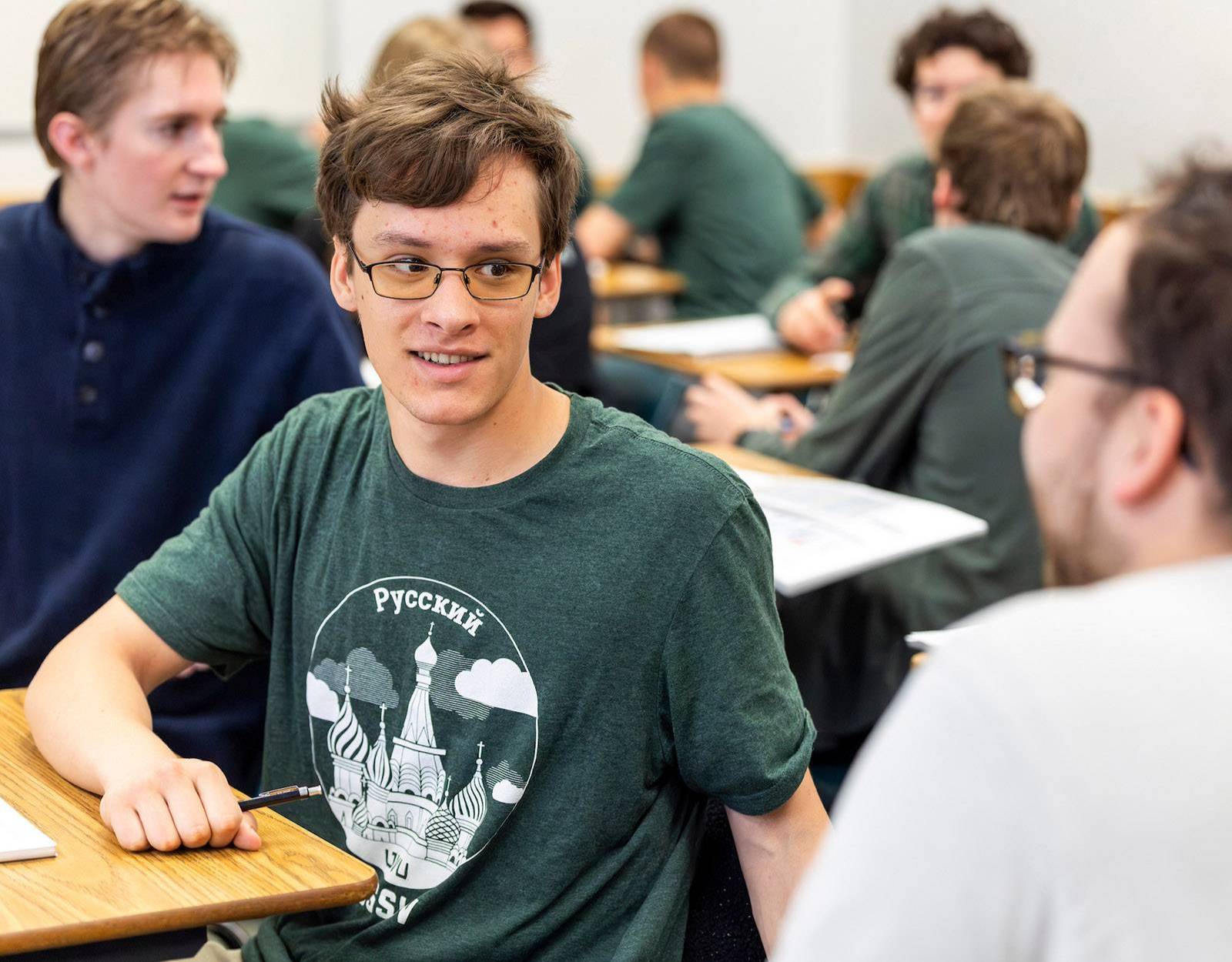 Student with a Russian Studies shirt on, interacting with others in class