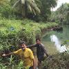 Two men on a river posing for a picture.