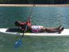 Student laying down on a paddle board
