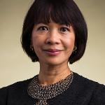A headshot of president Tuminez with short black hair and a black blouse