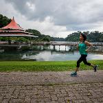 President Tuminez running outdoors past a red pagoda