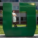 President Tuminez standing outdoors in a large green letter U