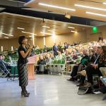 President Tuminez standing in an auditorium while talking to a room full of people