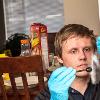 A man uses a duster to look for fingerprints on a door