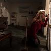 A woman puts her eye up to a device to better analyze blood splatter