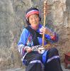 Ethnic Yi Lady who is playing Yi traditional Musical instrument San Xian (three-string Guitar). The Yi people are a nationality in China who are good at singing, dancing and playing instruments. China - Photo by Alex Yuan