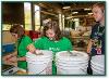 Girl in green shirt scooping stuff of out large bucket