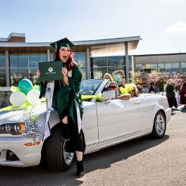 UVU Graduate in front of car