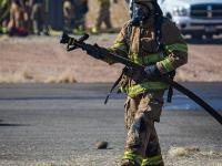 Firefighter carrying a firehose