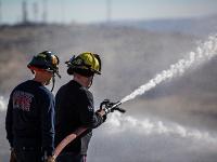 Firefighters spraying water out of a firehose