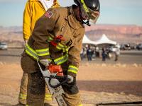 Firefighter sawing plywood on the ground