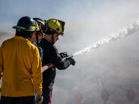 Firefighters spraying water out of a firehose