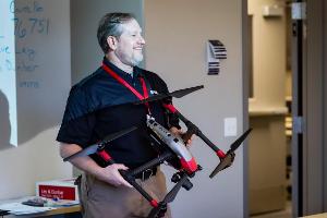An instructor holding a big drone
