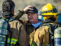 A group of firefighters being instructed by another firefighter without gear