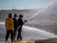 Firefighters spraying water out of a firehose