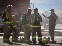 A group of firefighters being instructed by another firefighter without gear