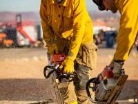 Firefighter sawing plywood on the ground