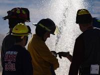 Firefighters spraying water out of a firehose