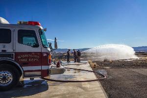 Firefighters spraying with firehose