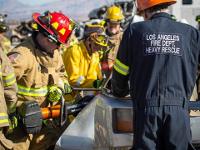 A group of firefighters looking at an overturned car