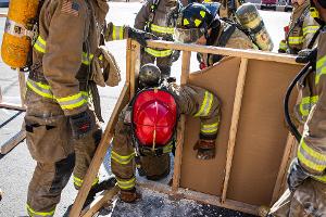 Firefighters using a crowbar on a wooden structure