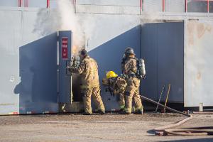 Firefighters going through a metal door